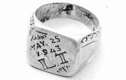 A vintage silver ring featuring an engraved date of May 25, 1943, and the Roman numeral 'LII'.
